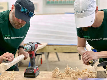 Två Prologis-medarbetare som slipar trä under ett IMPACT Day-projekt